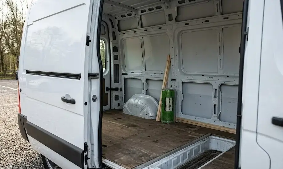Fourgon utilitaire blanc (Renault Master L2H2) avec structure de plancher en bois, prêt pour l'isolation et l'aménagement VASP.