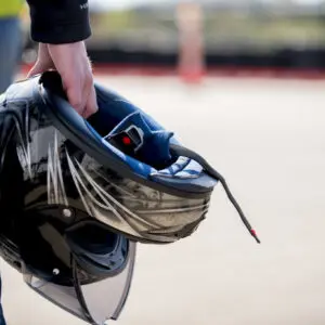 Motard tenant son casque, prêt pour les démarches de changement de titulaire d'une carte grise moto.