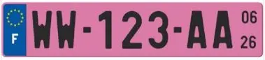 Gros plan sur une plaque d'immatriculation provisoire de couleur rose avec caractères noirs, installée sur un véhicule récent.